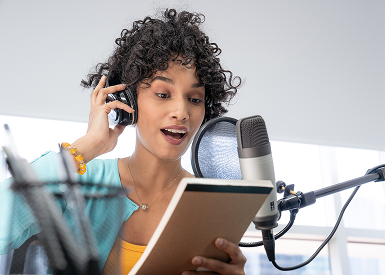 Woman reading from script into microphone