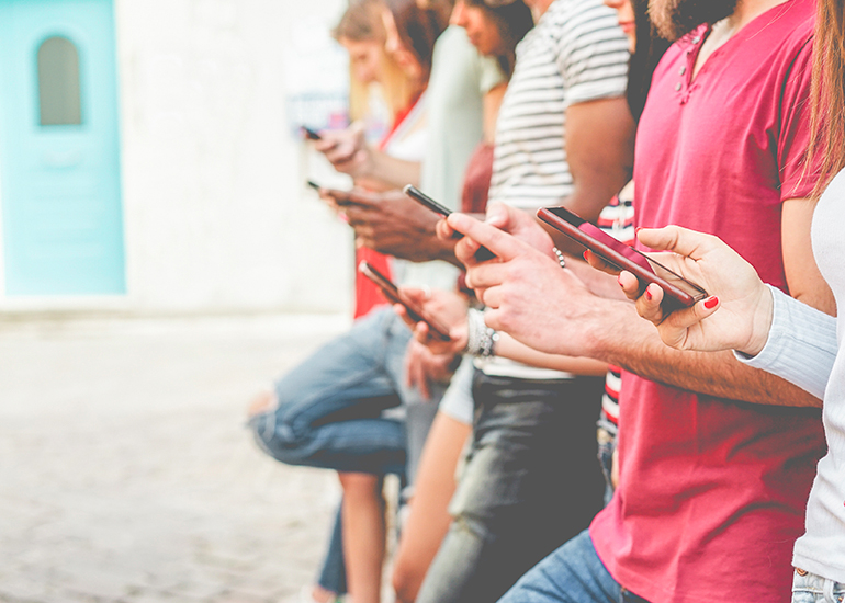 Line of young people using mobile phones