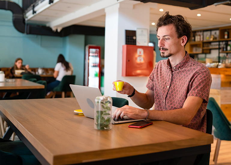 man working on laptop in cafe