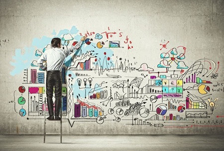 man on step ladder drawing large infographic on wall