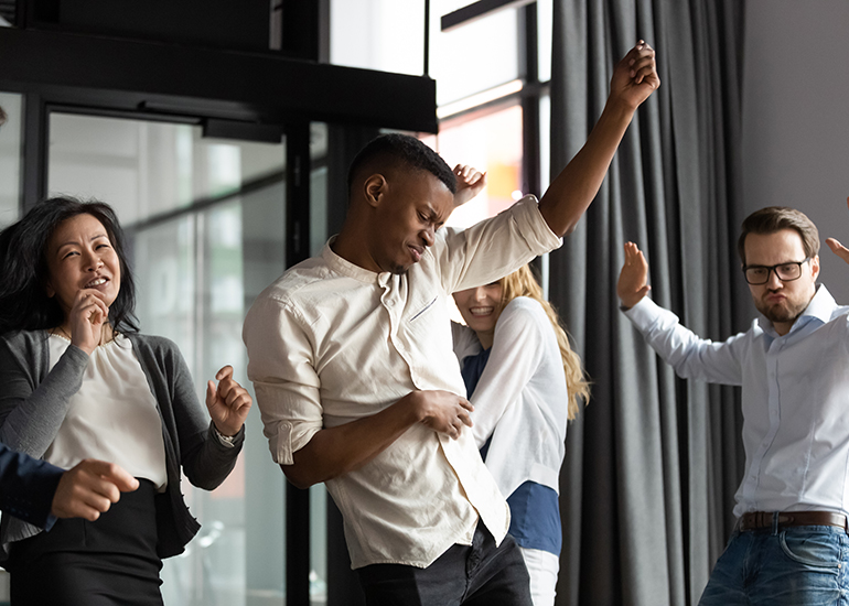 happy people dancing in office celebrating success