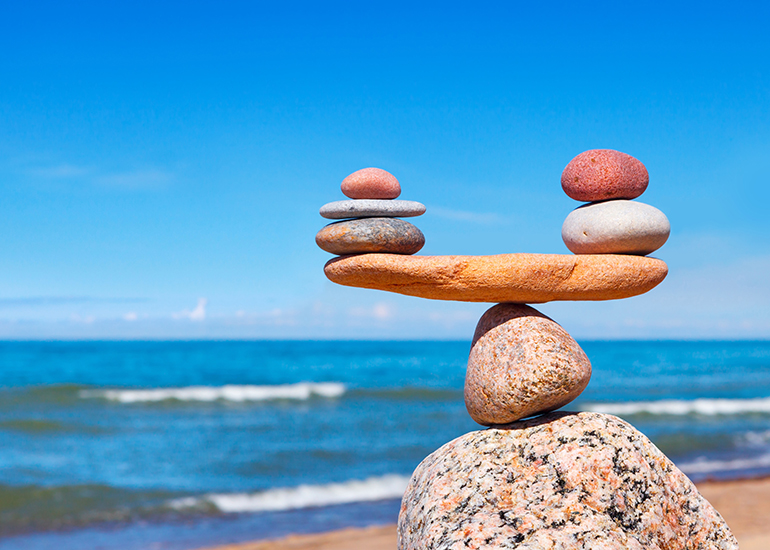 Zen stones balanced like scales at the beach