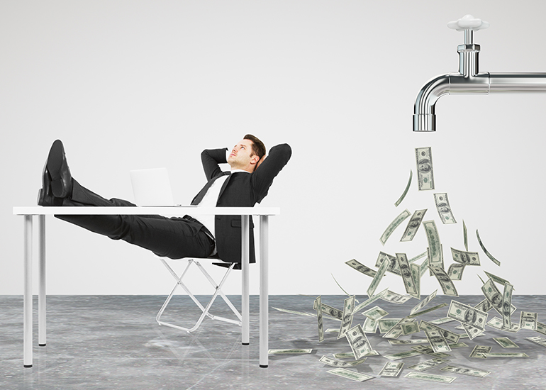 Man with feet on desk relaxing while cash money pours from tap behind him