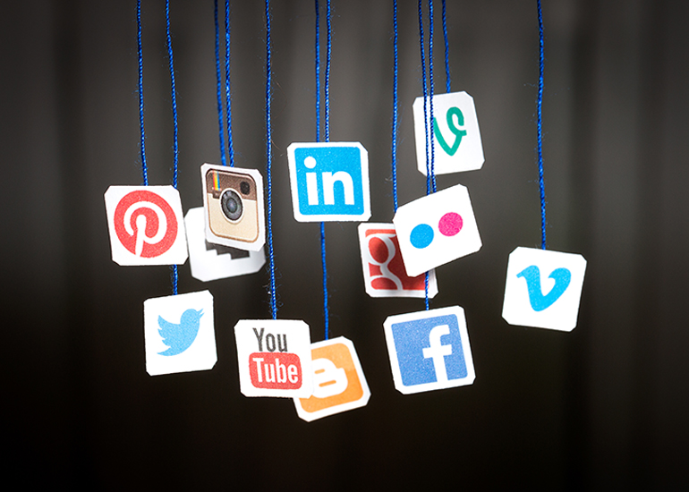 Various social media icons hanging by blue threads
