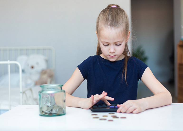 Young girl using calculator to count her savings