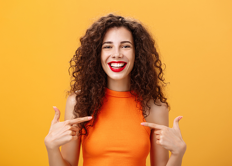 Smiling and confident woman pointing to herself