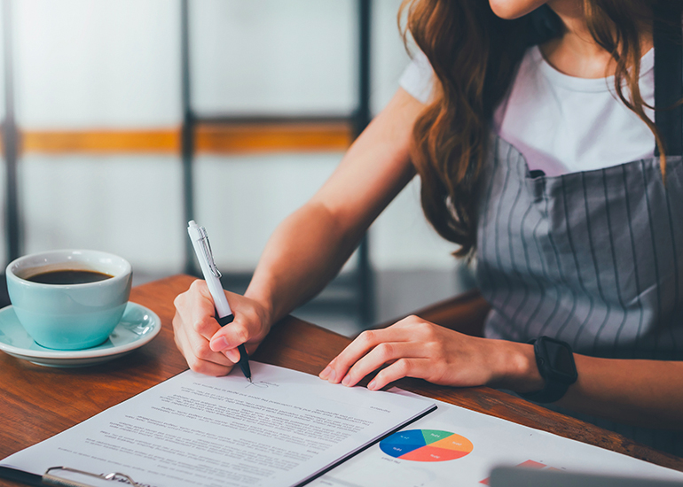 Small business cafe owner signing legal contract documents