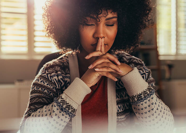 woman meditating with eyes closed