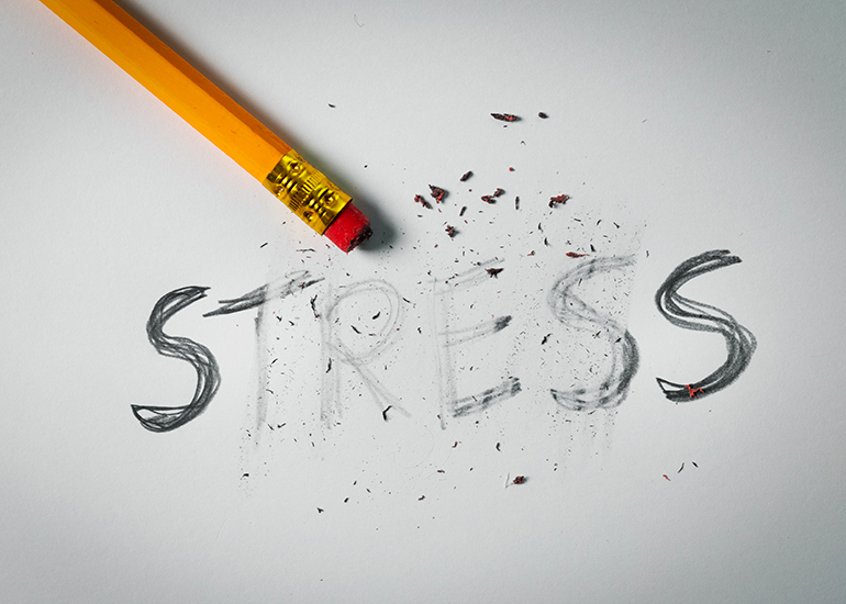 Pencil erasing the word stress written on a blank page