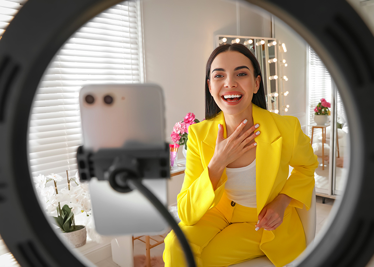 Woman using smartphone to chat on video call with ring light