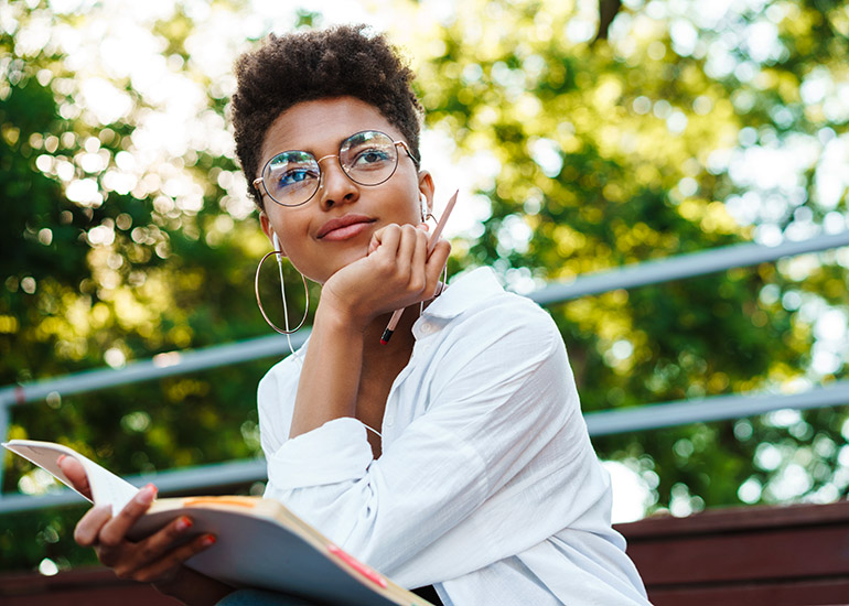 woman on park bench thinking deeply and writing