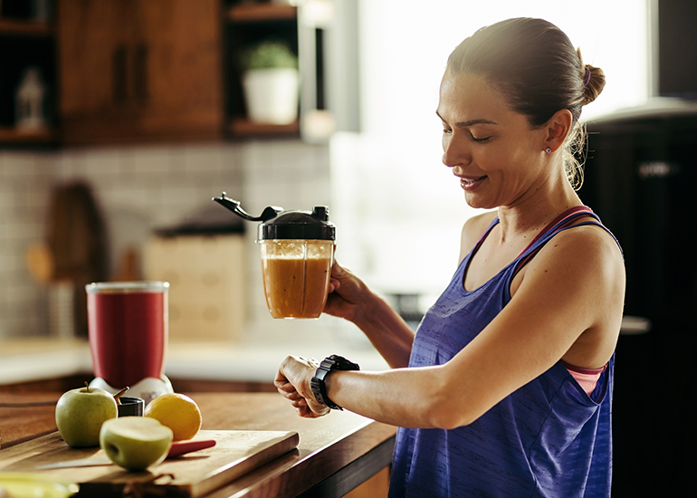 Healthy woman in kitchen cutting fruit
