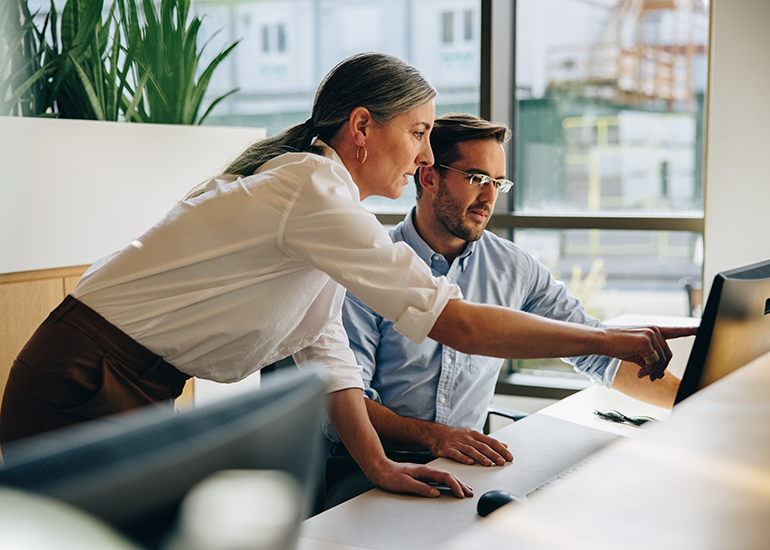 Woman and man working together at office desk