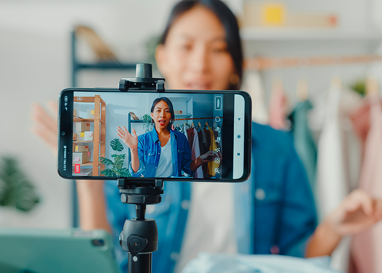 Young woman creating social media video in fashion studio