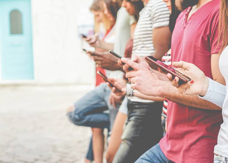 Line of young people using mobile phones