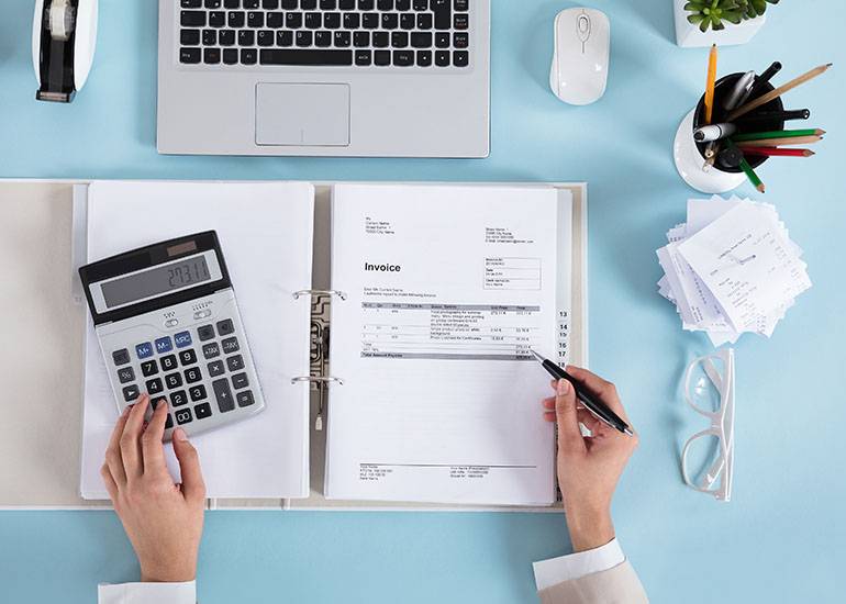 woman checking invoices - cash vs accrual
