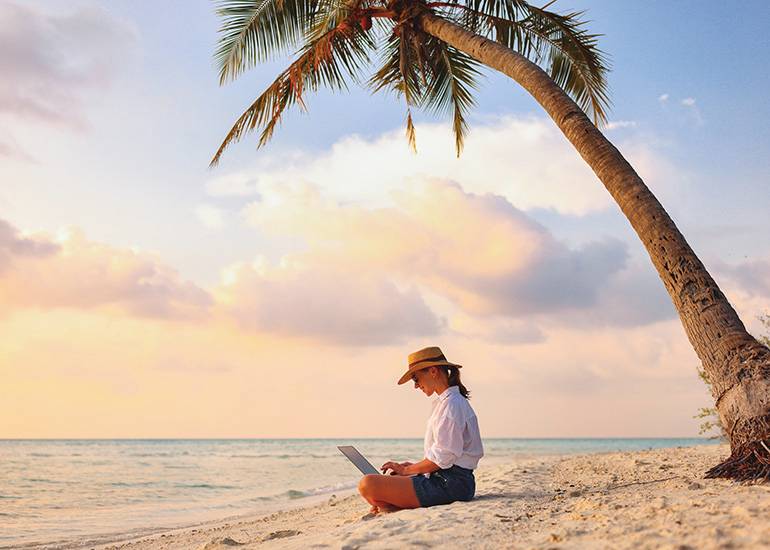 woman working on laptop at beach