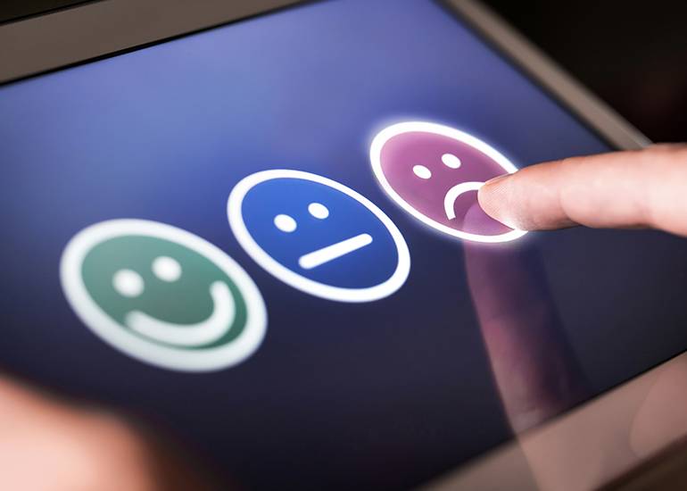 customer pressing sad face button to indicate a negative review - customer experience