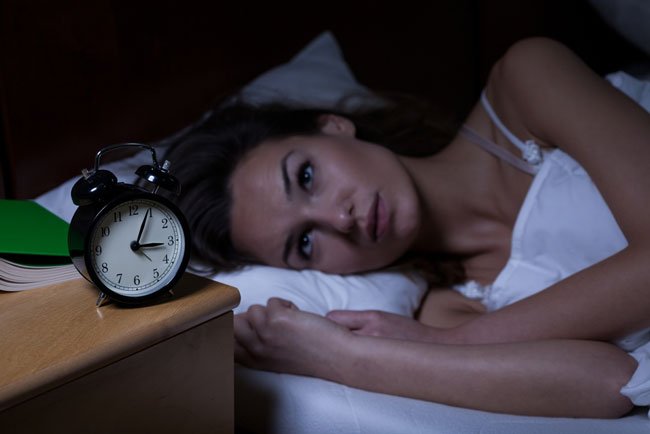 Woman lying awake in bed at night