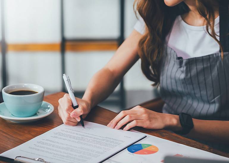 Small business cafe owner signing legal contract documents