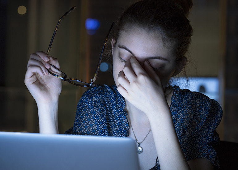 Tired young woman working on computer