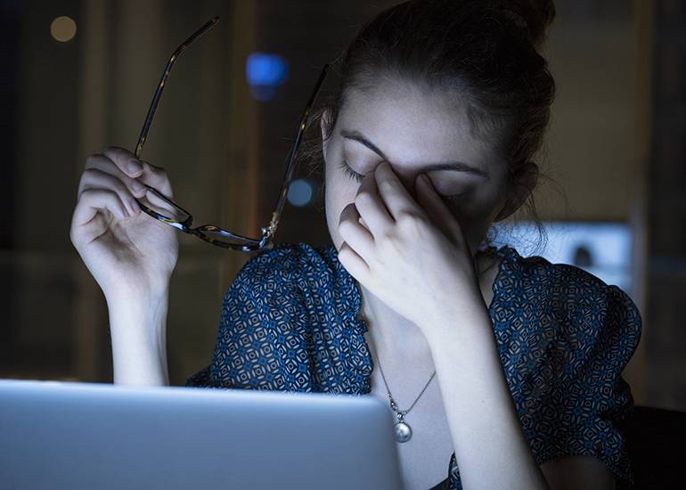 Tired young woman working on computer
