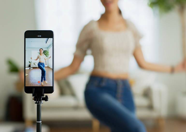 woman creating dancing social media video on phone