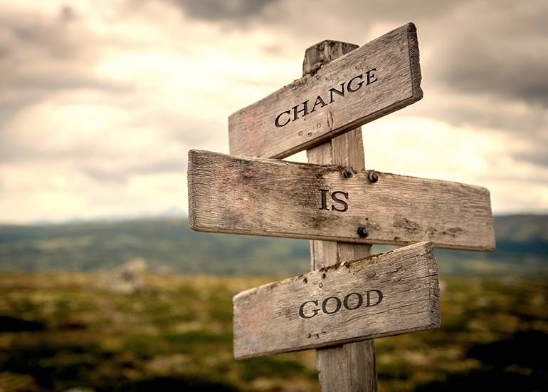 Wooden signpost with the words ‘change is good’