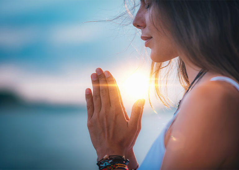 woman meditating or praying outdoors