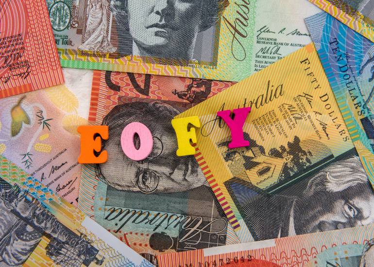 Wooden letters 'EOFY' on australian dollars background