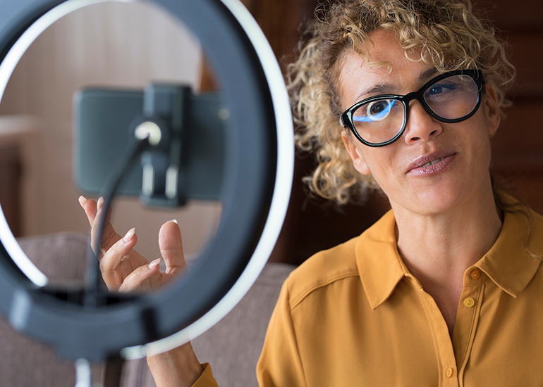 Woman creating video with phone and ring light