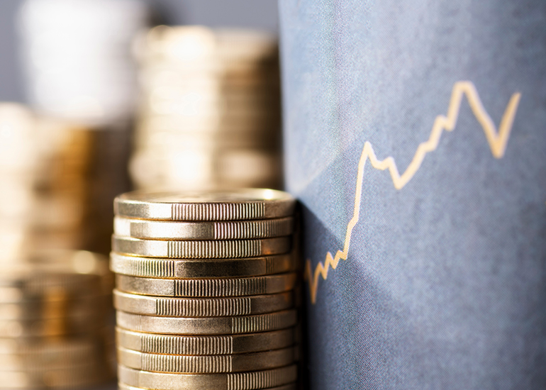 Stack of coins in front of blackboard with graph