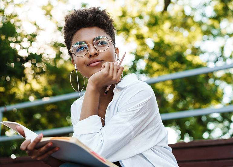 woman on park bench thinking deeply and writing
