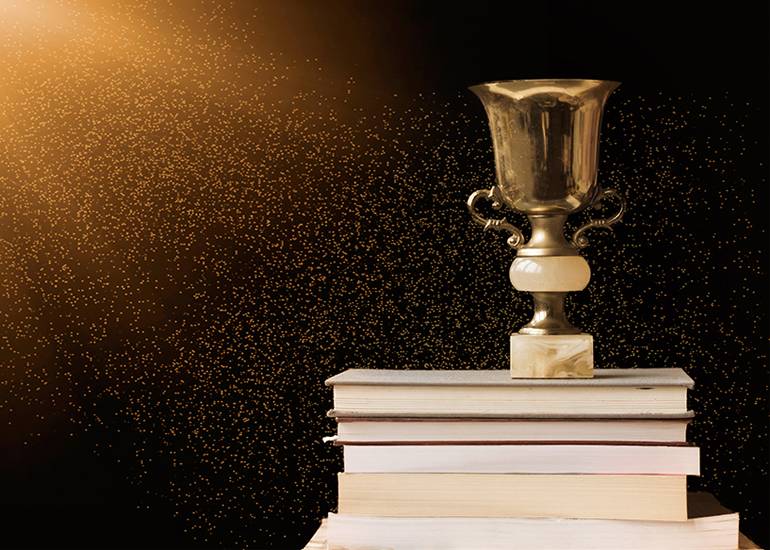 Trophy sitting atop pile of books