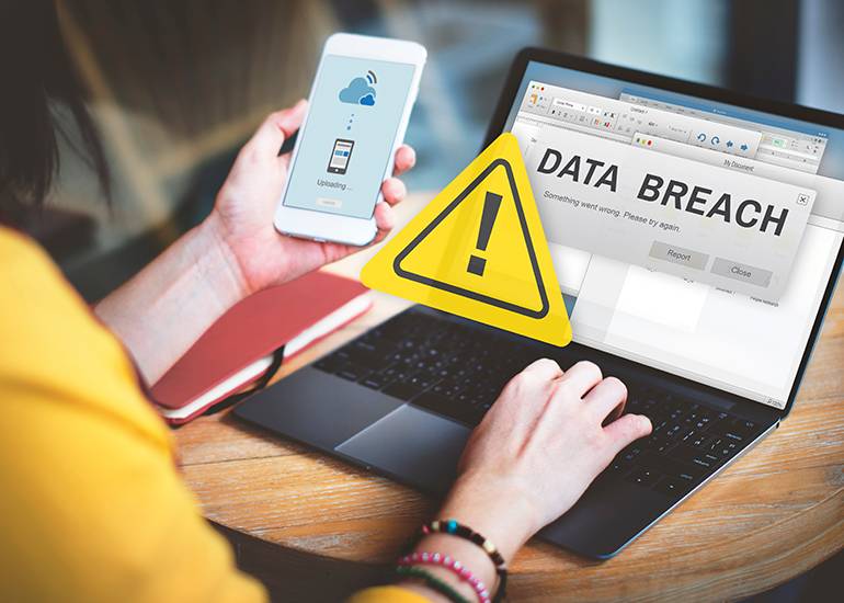 Data breach warning showing on laptop and phone