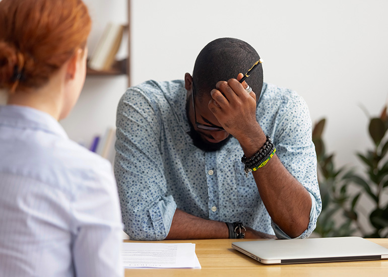 Man with head in hands at work desk