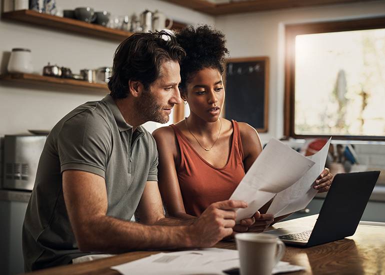 worried couple looking at bills