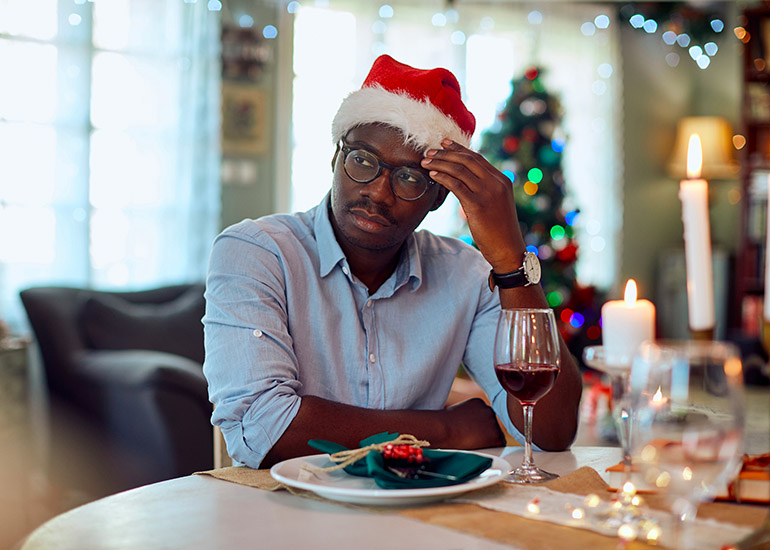 Unhappy man sitting alone at Christmas table