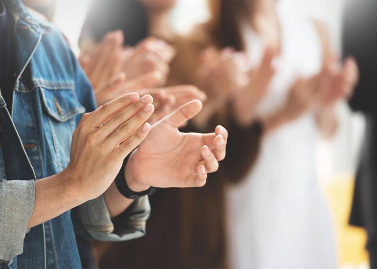 Crowd clapping in applause recognition of an award