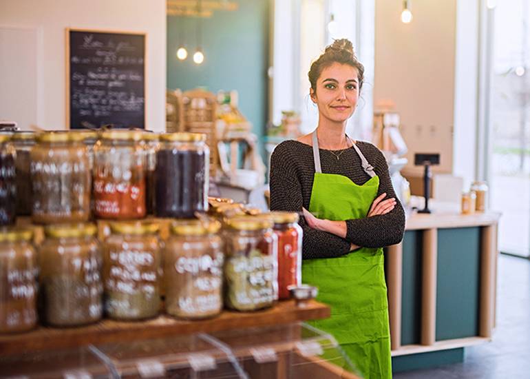 Female shop owner standing in store with arms crossed