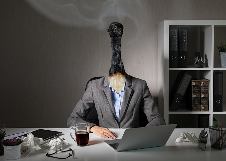 Executive at desk with burnt matchstick for a head