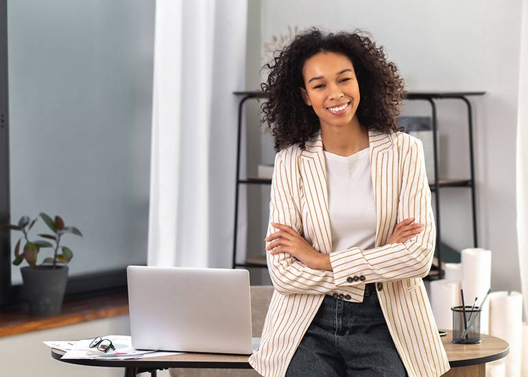 Female entrepreneur at desk with arms crossed