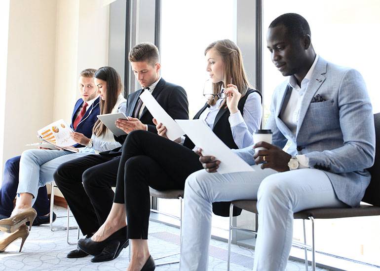 Well-dressed young execs lined up for job interview with resumes