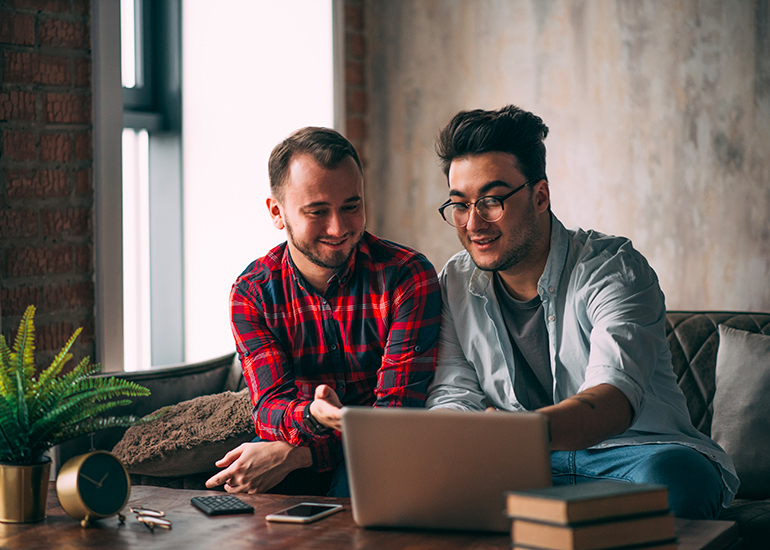 same sex couple looking at computer