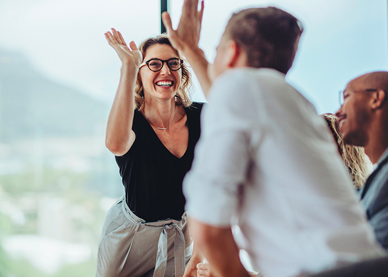 team high fiving in office