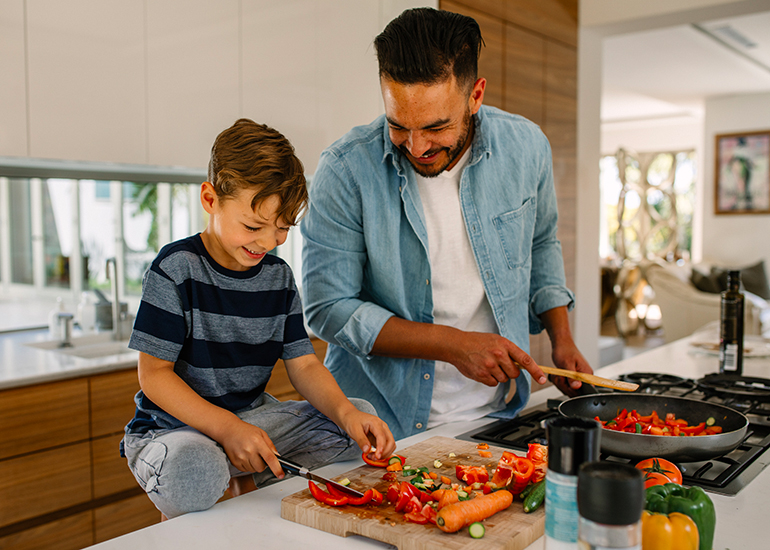 Father cooking with young boy in kitchen
