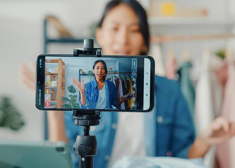 Young woman creating social media video in fashion studio