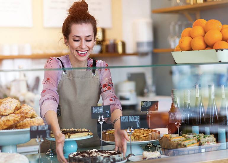 woman adjusting cafe bakery display