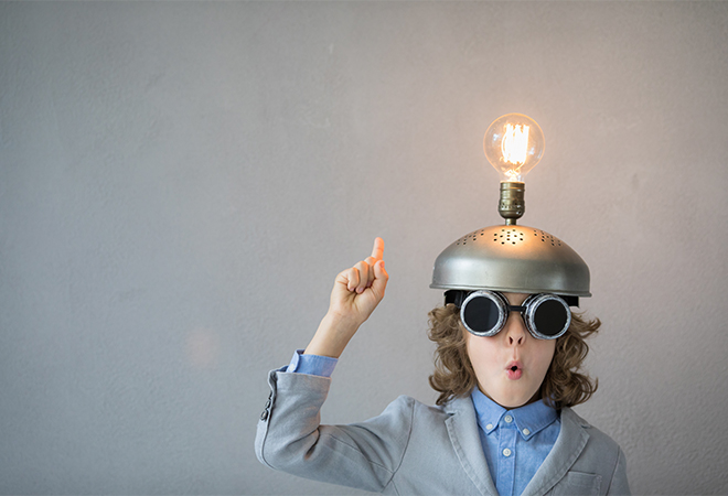 Child with lightbulb on helmet depicting a bright idea