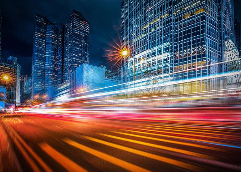 Growth concept, blurred lines of taillights accelerating through a cityscape
